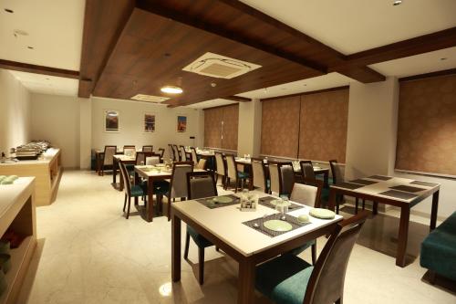 ein Restaurant mit Tischen und Stühlen in einem Zimmer in der Unterkunft Hotel Taviral Regency in Udaipur