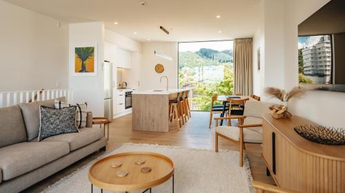 a living room with a couch and a table and a kitchen at Beautiful urban apartment 1 in Nelson