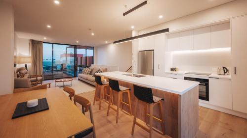 a kitchen and living room with a table and chairs at Beautiful urban apartment 1 in Nelson