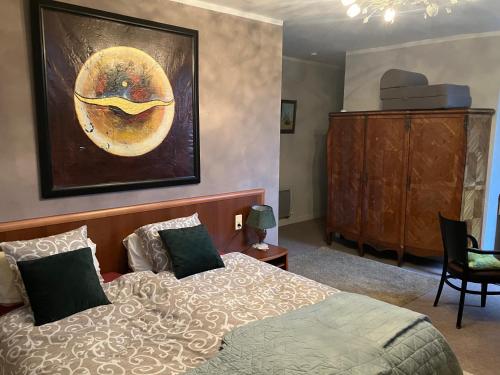 a bedroom with a bed and a painting on the wall at moon river chambre d'hote in Saint-Junien