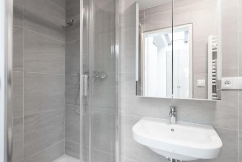 a bathroom with a sink and a shower with a mirror at Astronomical Clock Apartment in Prague