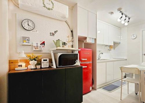 a kitchen with a microwave and a red refrigerator at Evermore #Sinchon station 5min #Seogang station 1min in Seoul