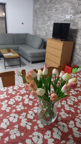 a vase of flowers on a table in a living room at Avalon Vendégház in Levelek