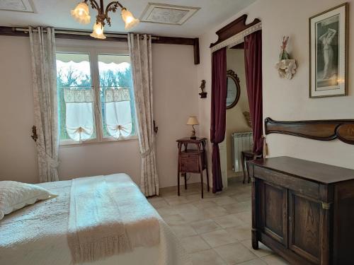 a bedroom with a bed and a dresser and a window at La Vendemiere - Maison d'hôtes de charme et de caractère, Bretagne, Côtes d'Armror in Pont-Melvez