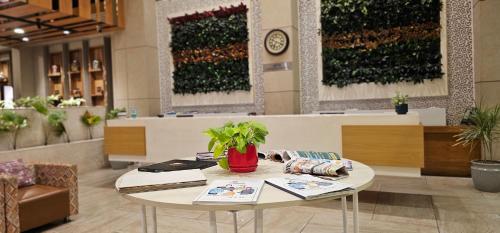 a lobby with a table with a plant on it at Ginger Kochi MG Road in Cochin