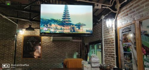uma televisão de ecrã plano pendurada numa parede de tijolos em V House em Phra Nakhon Si Ayutthaya