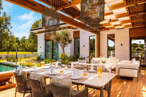 a dining room with a table and chairs and a pool at Kempinski Hotel The Dome Belek in Belek