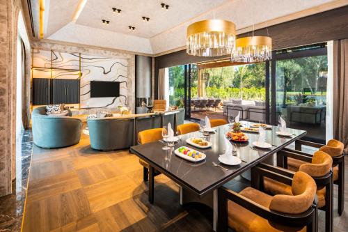 a dining room and living room with a table and chairs at Kempinski Hotel The Dome Belek in Belek