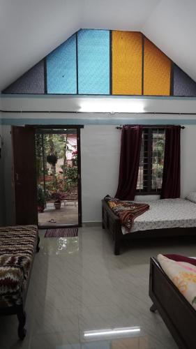 a room with two beds and a large window at Best Kerala Homestay in Kattappana