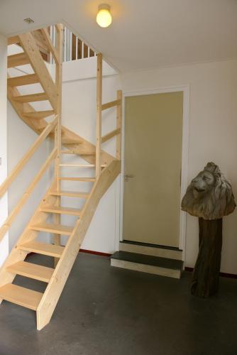a wooden staircase in a room next to a door at Historische Boerderij FAMILIEKAMER in Heinkensand
