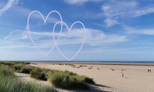 a heart drawn in the sand on a beach at AnchorageWells Holiday Cottage and King Ensuites Room Only in Wells next the Sea