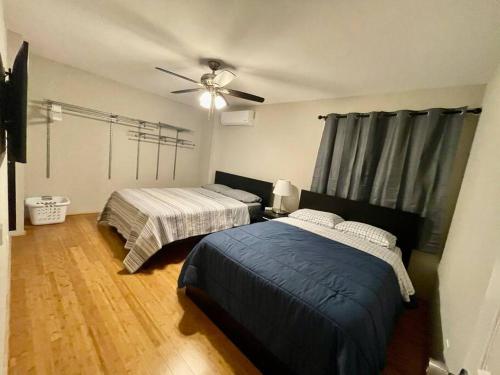 a bedroom with two beds and a ceiling fan at Spacious 1670 sq ft Single Home with Garage, AC, Centrally Located in San Diego