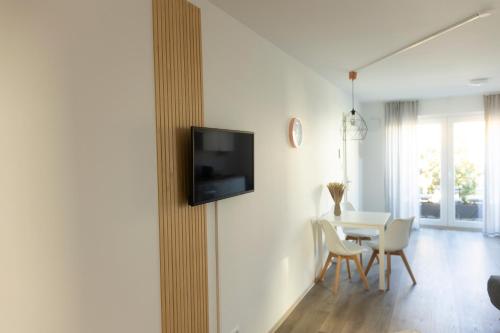 un soggiorno con tavolo e TV a parete di HUGOS Studio Apartment a Bensheim