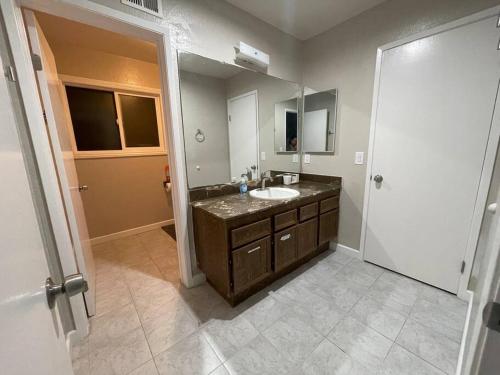 a bathroom with a sink and a mirror at Spacious 1670 sq ft Single Home with Garage, AC, Centrally Located in San Diego