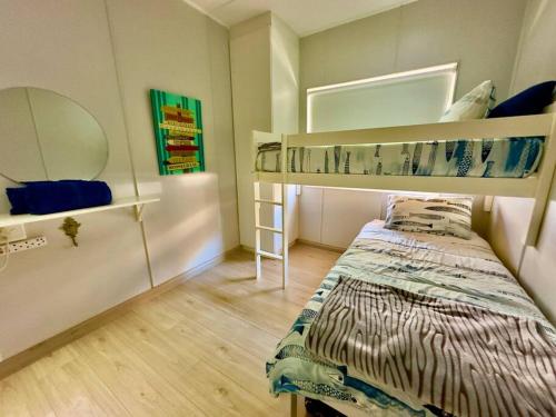 a bedroom with a bed and bunk beds in it at The Perfect Hartenbos Holiday Home in Mossel Bay