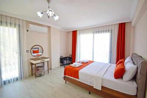 a bedroom with a large bed with red curtains at Villa Kozalak 1 in Fethiye