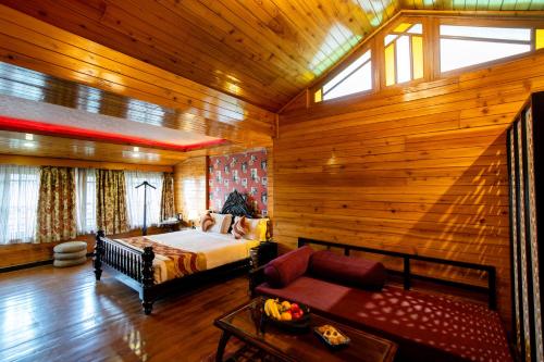 a bedroom with a bed and a couch in a room at Hotel Viceroy in Darjeeling