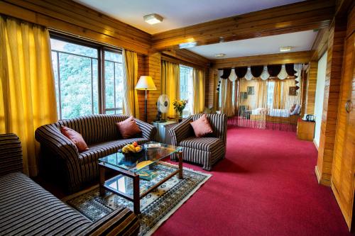 a living room with two couches and a table at Hotel Viceroy in Darjeeling