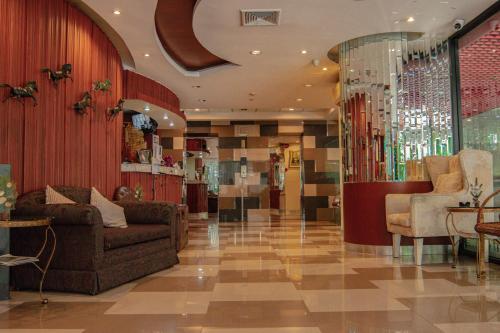 a lobby with couches and chairs in a building at The Sunreno Hotel SHA in Bangkok