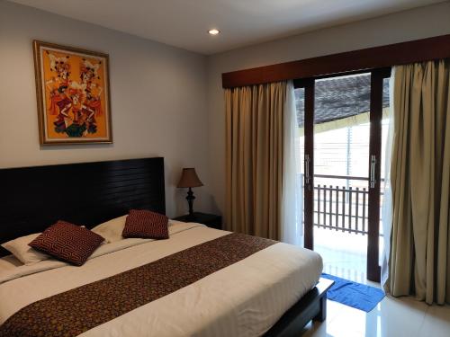 a bedroom with a large bed and a large window at Villa Lovecho in Canggu