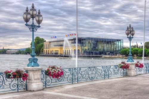 a fence with two lights and a building with a fountain at Le Carlier d'Enghien - 2 chambres - Près du Lac in Enghien-les-Bains