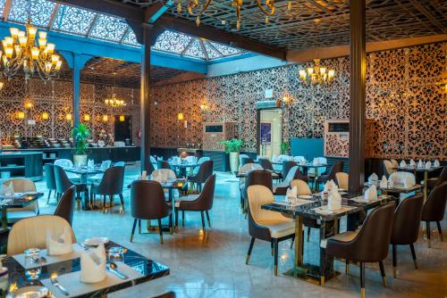 a restaurant with tables and chairs and a bar at Ezdan Hotel Doha in Doha