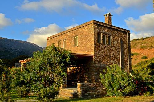 een oud bakstenen gebouw op een heuvel met struiken bij Onar Andros in Achla