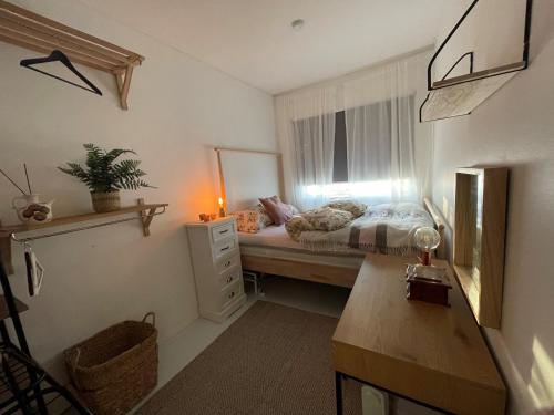 a small bedroom with a bed and a window at Arctic Homestay with Northern light view room in Tromsø