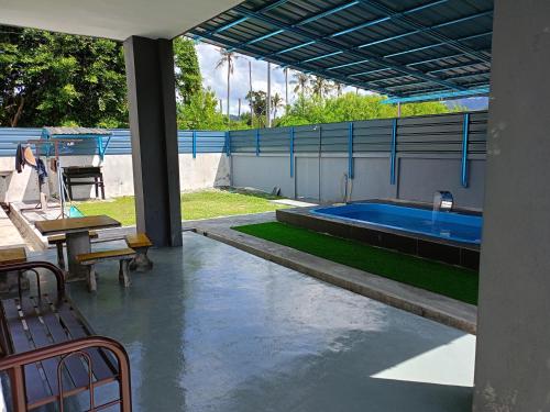 une terrasse avec une piscine dotée d'une table et d'un banc dans l'établissement hayfa homestay private pool ipoh, à Ipoh