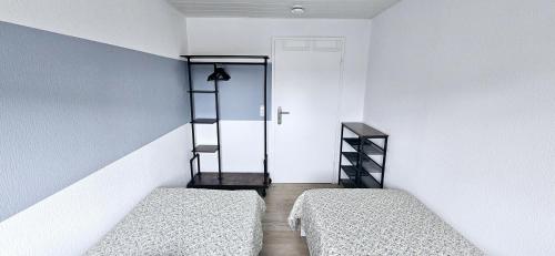 two beds in a room with white walls and a door at Büsummchen in Büsum