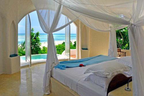 a bedroom with a bed with a view of the ocean at Kilindi Zanzibar in Kendwa