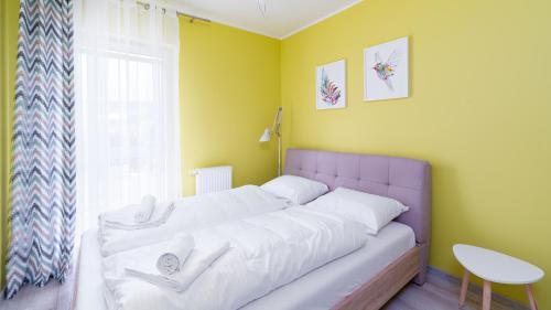 een slaapkamer met een bed met witte lakens en een raam bij Apartamenty Sun & Snow Waryńskiego in Szklarska Poręba