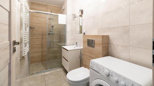 een kleine badkamer met een toilet en een douche bij Apartamenty Sun & Snow Waryńskiego in Szklarska Poręba
