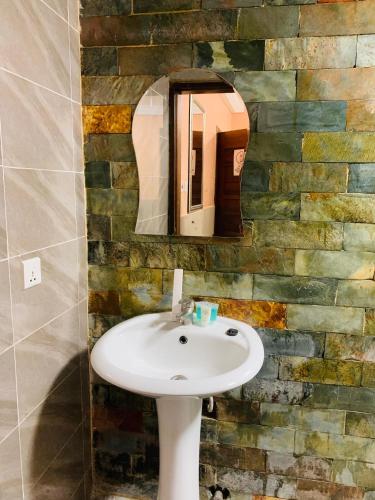 a bathroom with a sink and a mirror at Bays Boutique Apartment in Accra