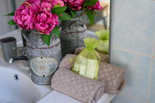 um balcão de casa de banho com um vaso de flores e um lavatório em La Casa di Betty em Lido di Ostia