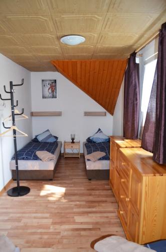 a bedroom with two beds and a wooden floor at Chata Zofka in Ižipovce