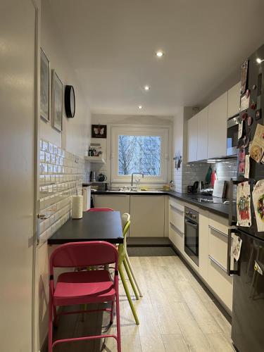 une cuisine avec une table et quelques chaises dans l'établissement Appartement familiale Paris - Mairie des Lilas, aux Lilas