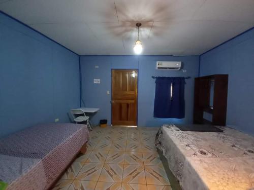 a bedroom with two beds and a blue wall at Hotel EL BOSQUE in Talamanca
