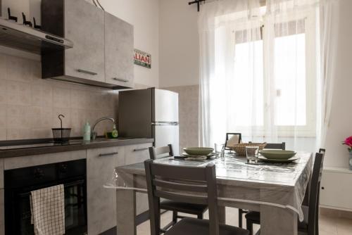 uma cozinha com uma mesa e cadeiras numa cozinha em La Casa di Betty em Lido di Ostia