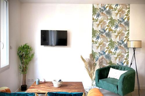 un salon avec une chaise verte et une table dans l'établissement Le Tropic-Elegant appart lumineux et central, au Havre