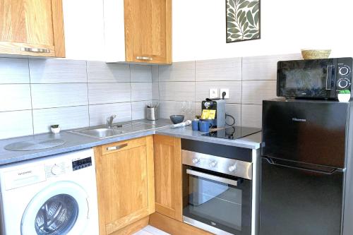 Il comprend une cuisine équipée d'un lave-linge, d'un évier et d'un lave-vaisselle. dans l'établissement Le Tropic-Elegant appart lumineux et central, au Havre