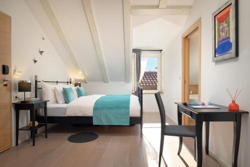 ein Schlafzimmer mit einem Bett, zwei Tischen und einem Fenster in der Unterkunft Perla Luxury Rooms in Split