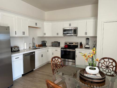 a kitchen with white cabinets and a table with a vase of flowers at The Place in Las Vegas