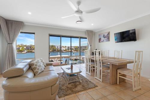 a living room with a couch and a table at Luxury 4 bedroom waterfront holiday home on the Sunshine Coast in Parrearra