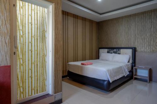 una piccola camera con letto e finestra di RedDoorz at Jalan Emmy Saelan Palu a Palu