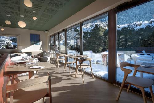 a room with tables and chairs and a large window at Lykke Hôtel & Spa Chamonix - ex Mercure in Chamonix-Mont-Blanc
