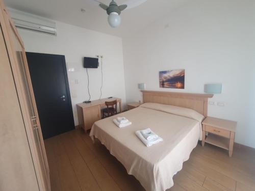 een slaapkamer met een bed met twee handdoeken erop bij HOTEL VILLA SANTANNA in Rimini