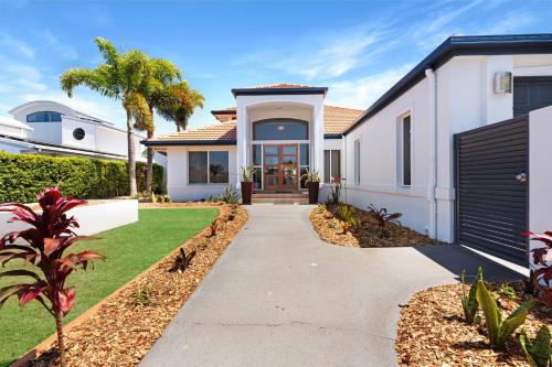a house with a pathway leading to the front door at Luxury 4 bedroom waterfront holiday home on the Sunshine Coast in Parrearra