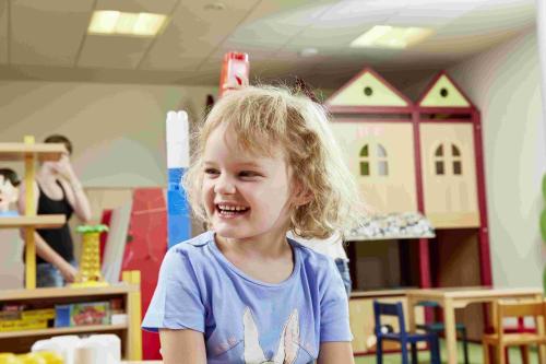 a little girl sitting in a play room at Dolomiten Residenz - Sporthotel Sillian in Sillian