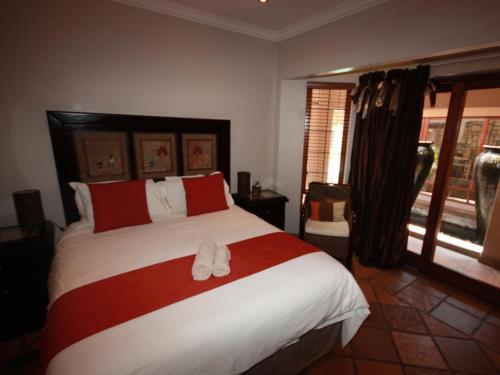 a bedroom with a large bed with two slippers on it at The Orion in Middelburg